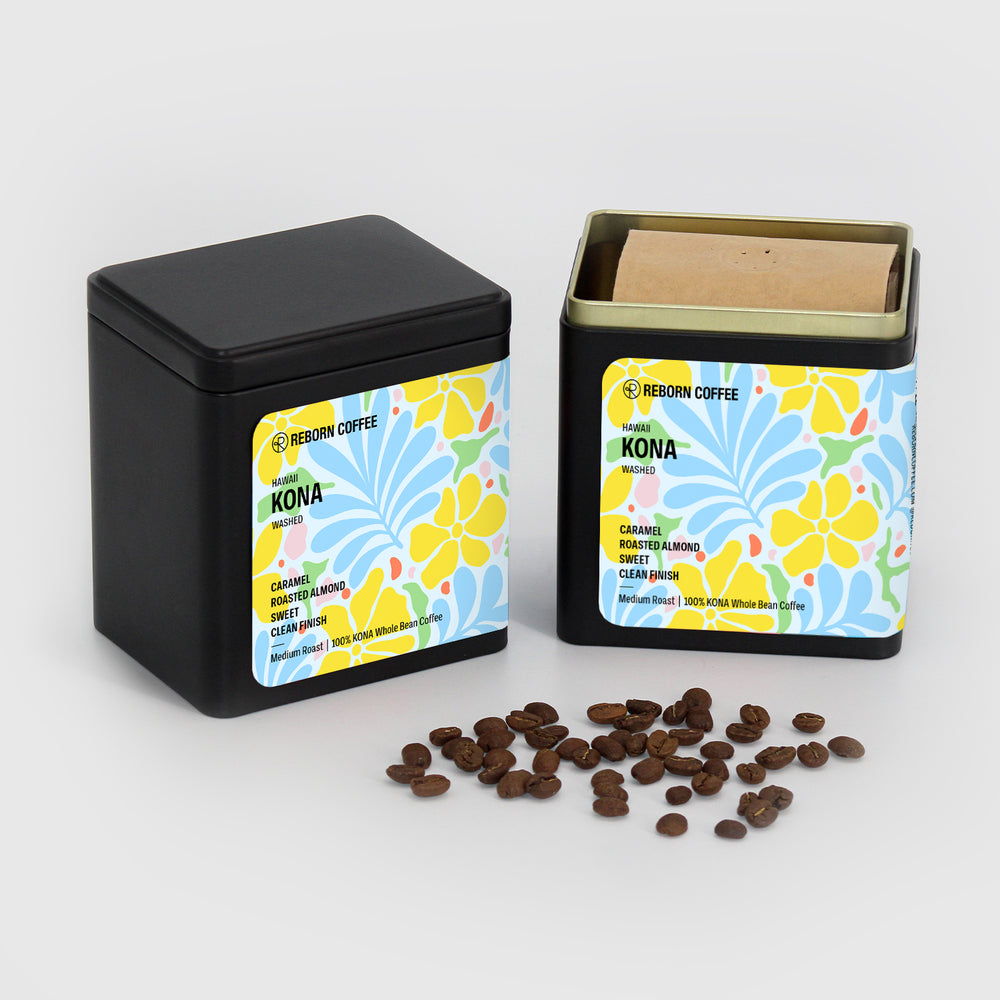 
                  
                    Two black metal boxes, one opened with Kona Coffee beans inside. Sticker shows product info imposed on floral design. Front view, 6 of 7.
                  
                