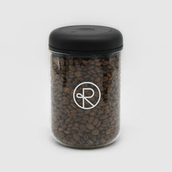 
                  
                    Fellow Atmos Vacuum canister with Reborn Coffee logo imprinted on glass, filled with coffee beans. Black, twist seal top with 1.2 liter glass canister. 2 of 5.
                  
                