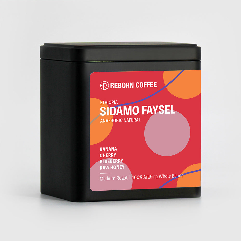 Black metal box with Ethiopia Sidamo Faysel Coffee beans inside. Sticker shows product info imposed on colorful background. Front Left View, 1 of 4.