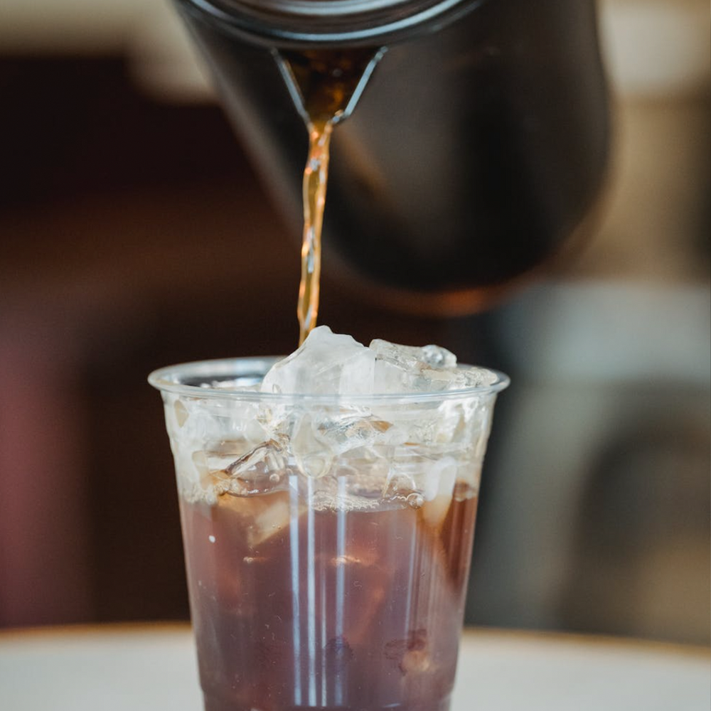 
                  
                    Cold brewed coffee being served from pitcher into plastic cup with ice. 8 of 9.
                  
                