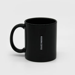 
                  
                    Black Ceramic mug with C handle has text, “Reborn Coffee.” 3 of 3.
                  
                